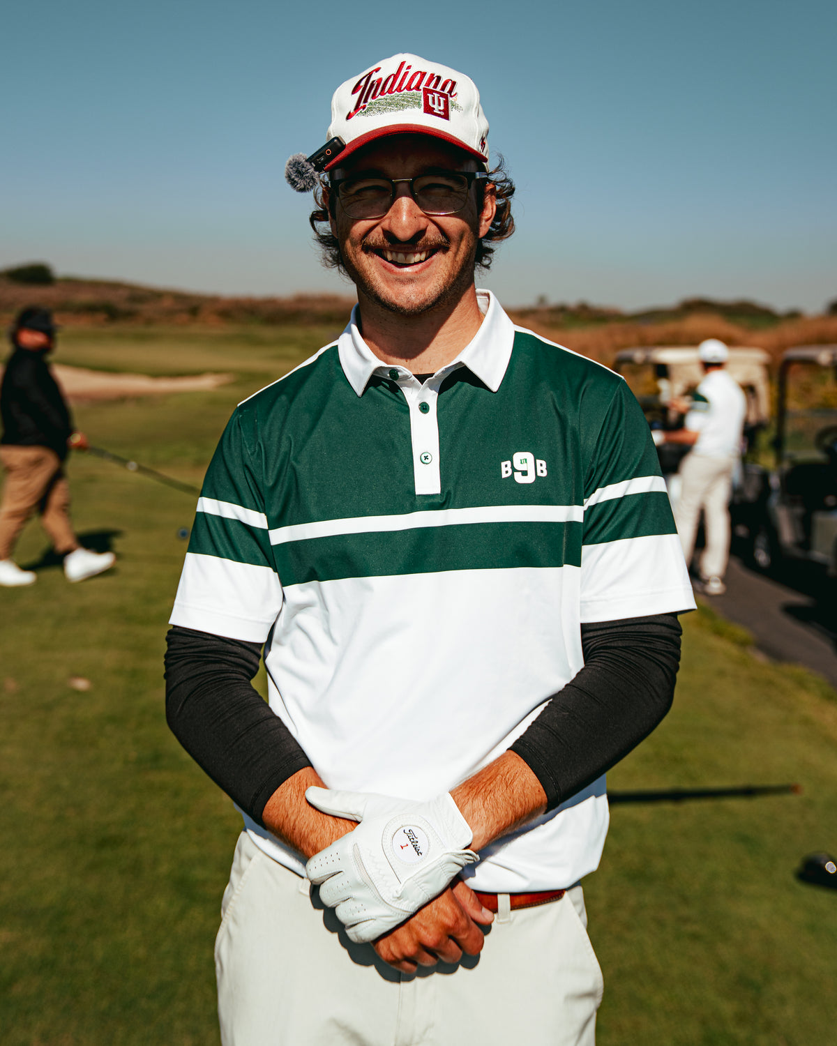 Golfer smiling in a green and white Back 9 Boys polo