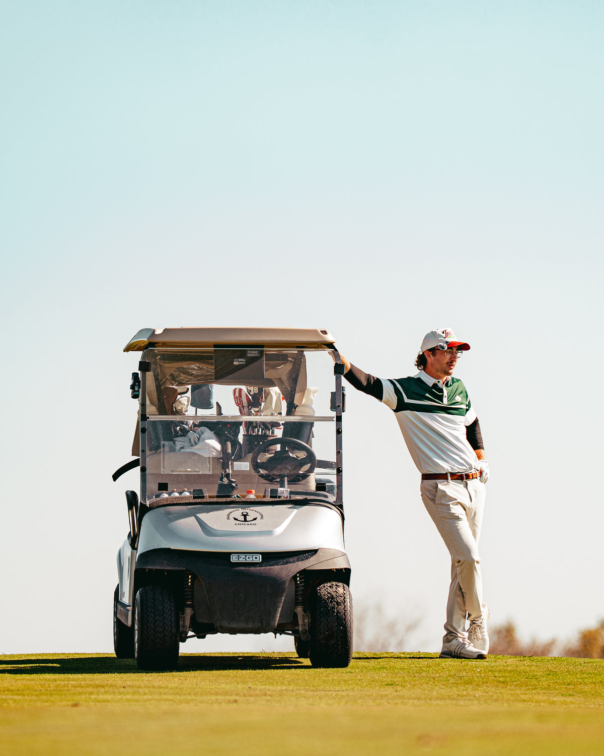 Golfer smiling in a green and white Back 9 Boys polo