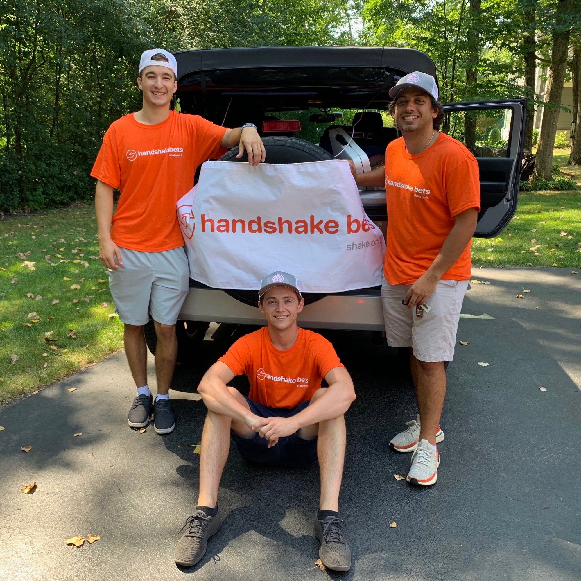 The three Handshake Bets founders together in front of a car in August 2020